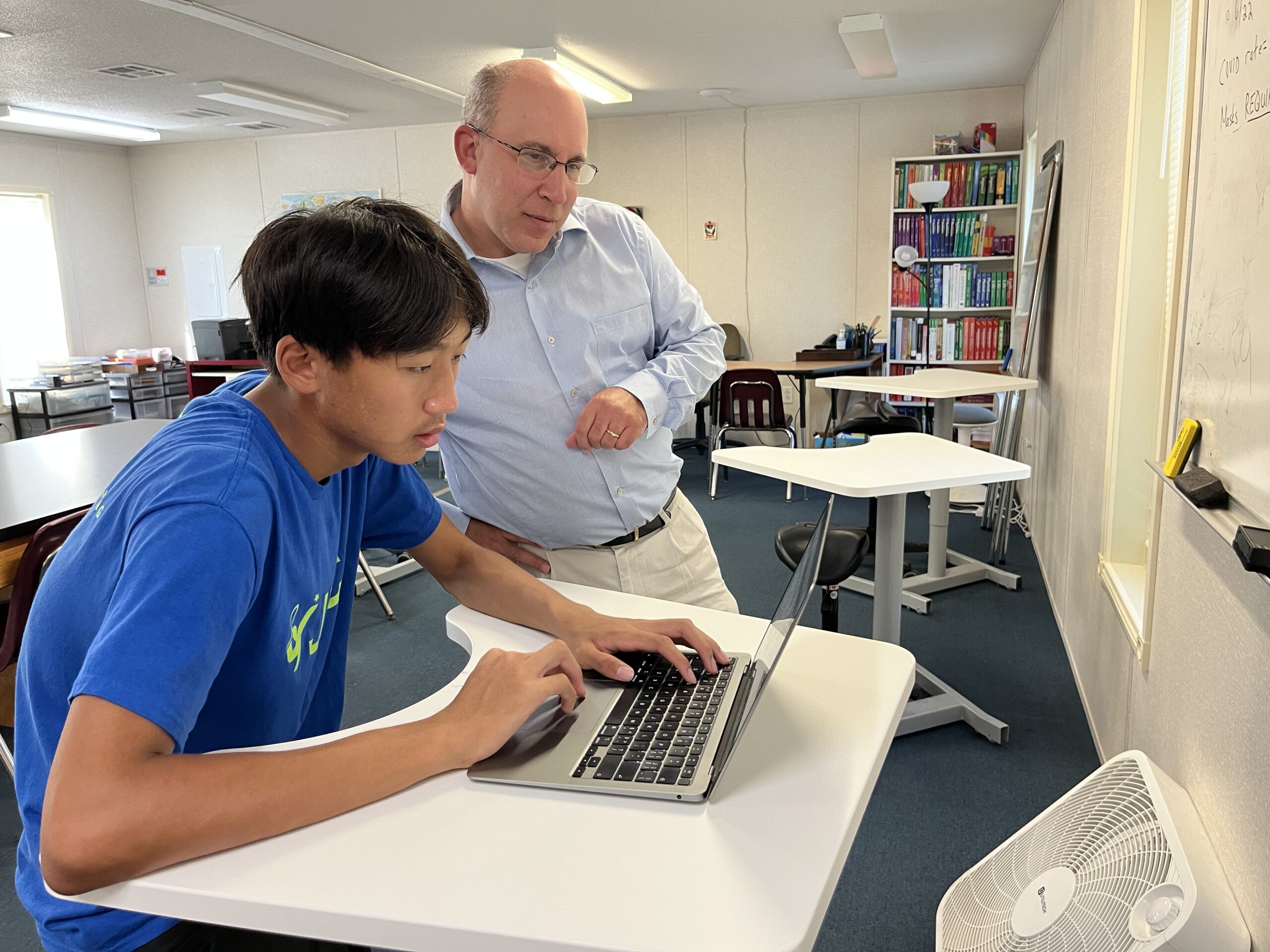 A JTCC teacher working with a student on campus